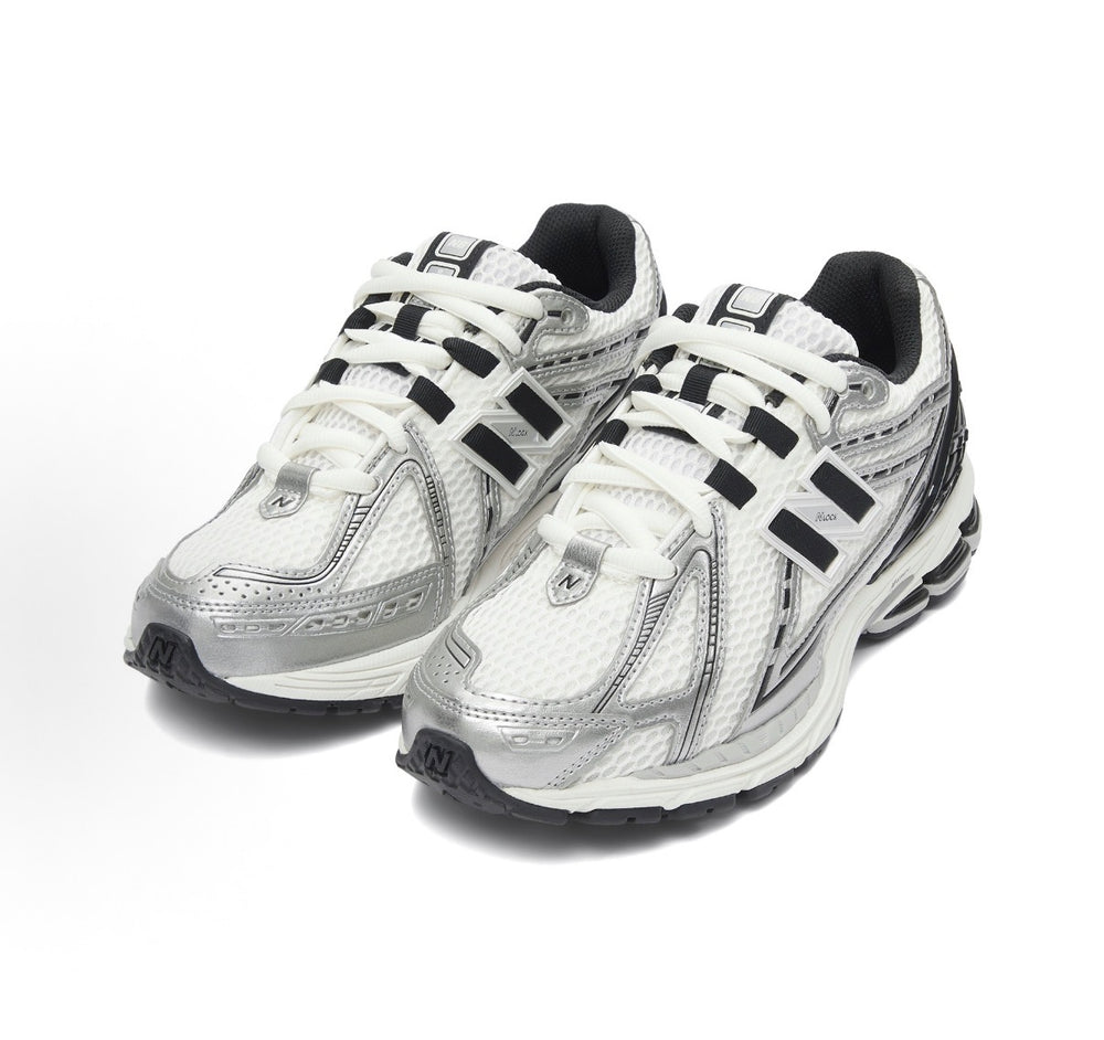 New Balance 1906R front three-quarter view: white laces, silver mesh, black accents.