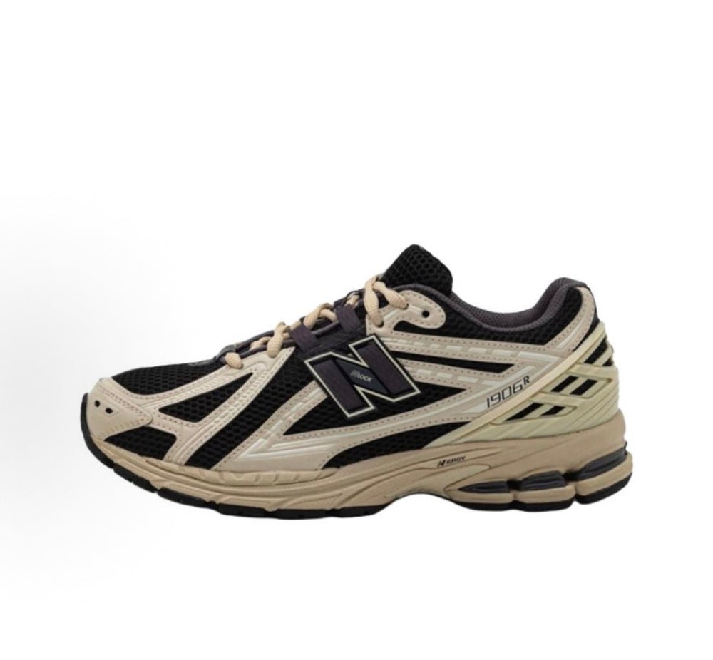 New Balance sneakers side profile in black and beige with chunky foam sole