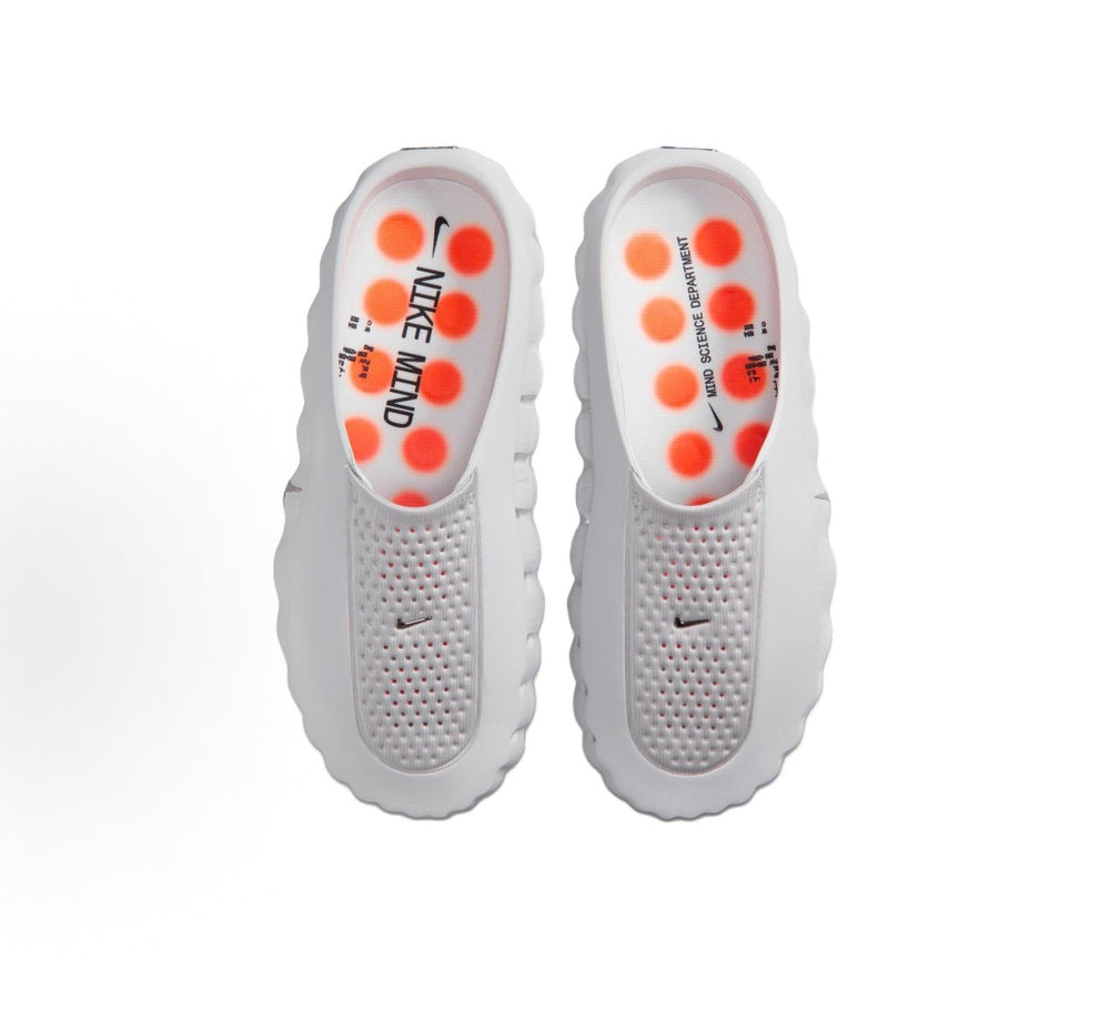 White slide sandals with perforated uppers and orange-dotted footbed detail