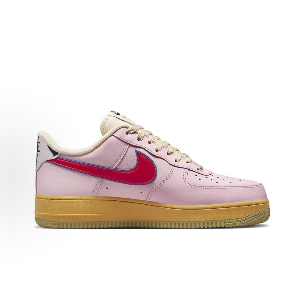 Low-top sneakers in pale pink leather with red swoosh and tan gum sole