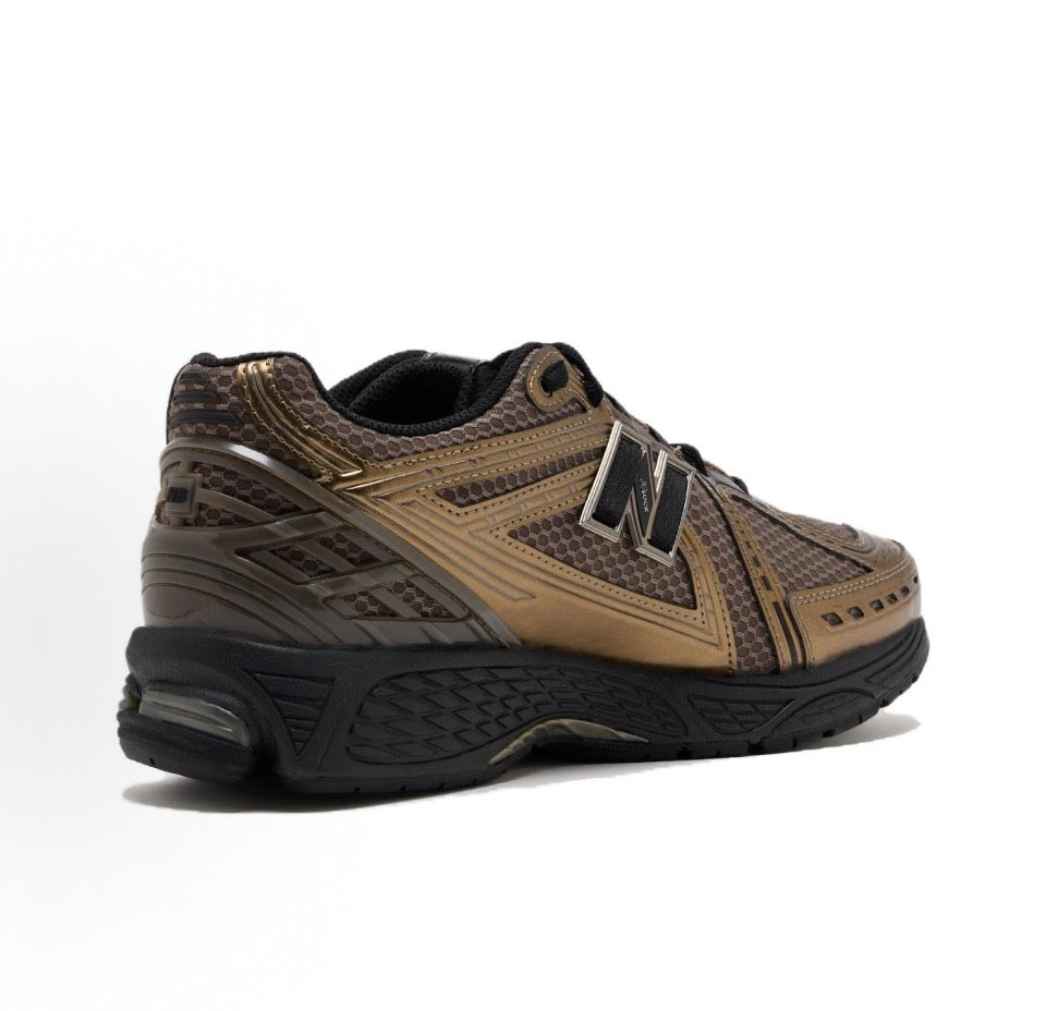 New Balance 1906R sneakers angled side view, tan upper with black sole and N logo