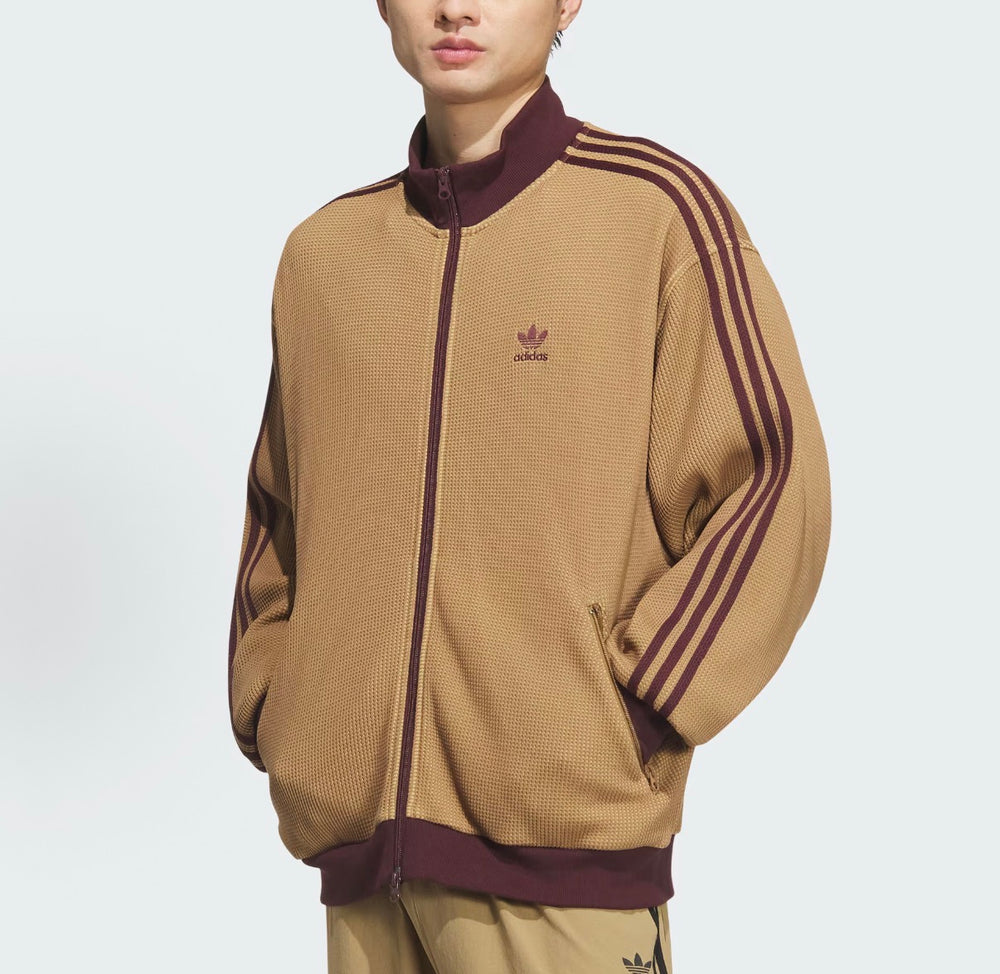 Adidas tan zip track jacket with maroon collar, chest logo, and three stripes