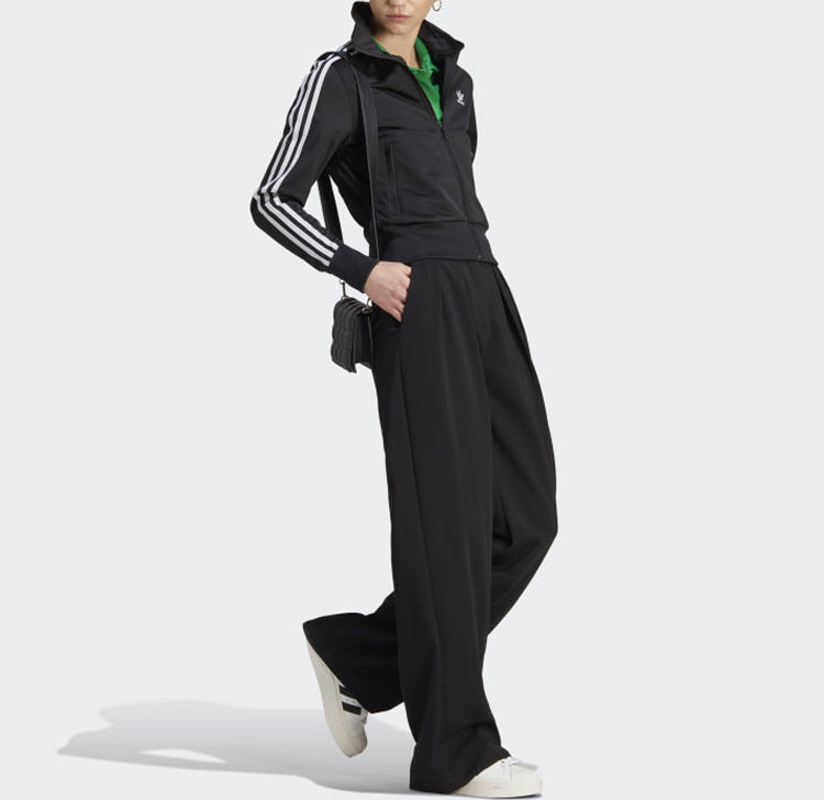 Black track jacket with white sleeve stripes and full zip worn with black pants