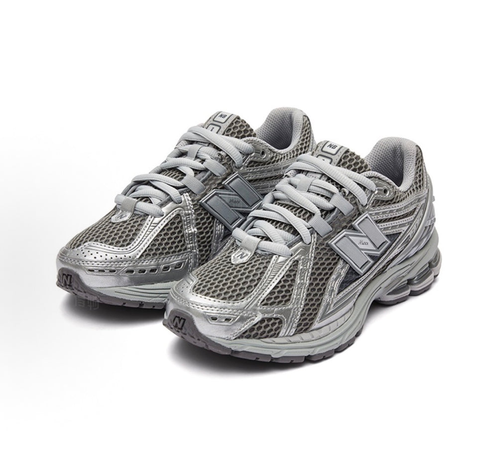 New Balance 1906R sneakers front quarter view, gray mesh with layered silver panels.