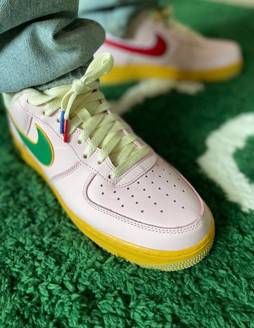 Low-top Nike Air Force 1 sneakers, white leather with gold midsole and green swoosh