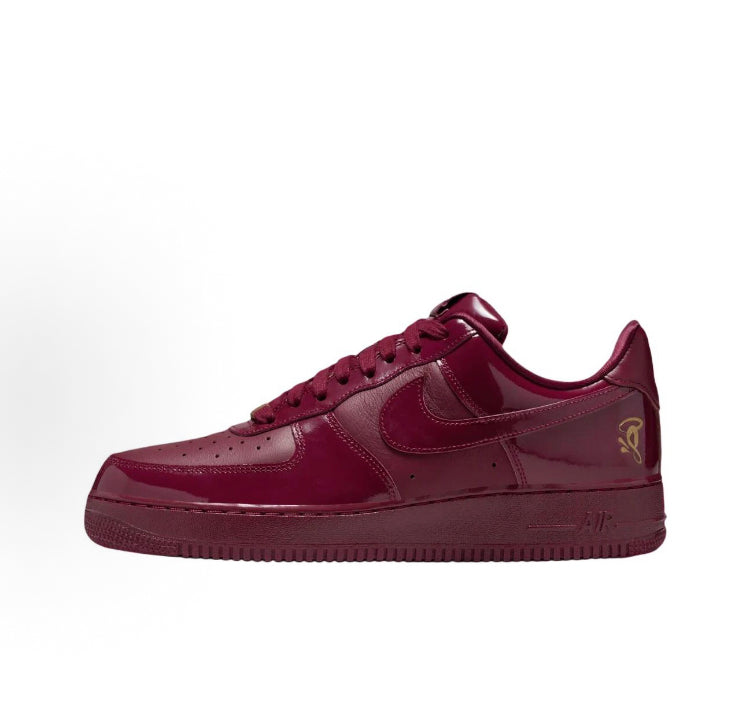 Dark maroon low-top sneaker side view with gold heel Air logo and Nike swoosh