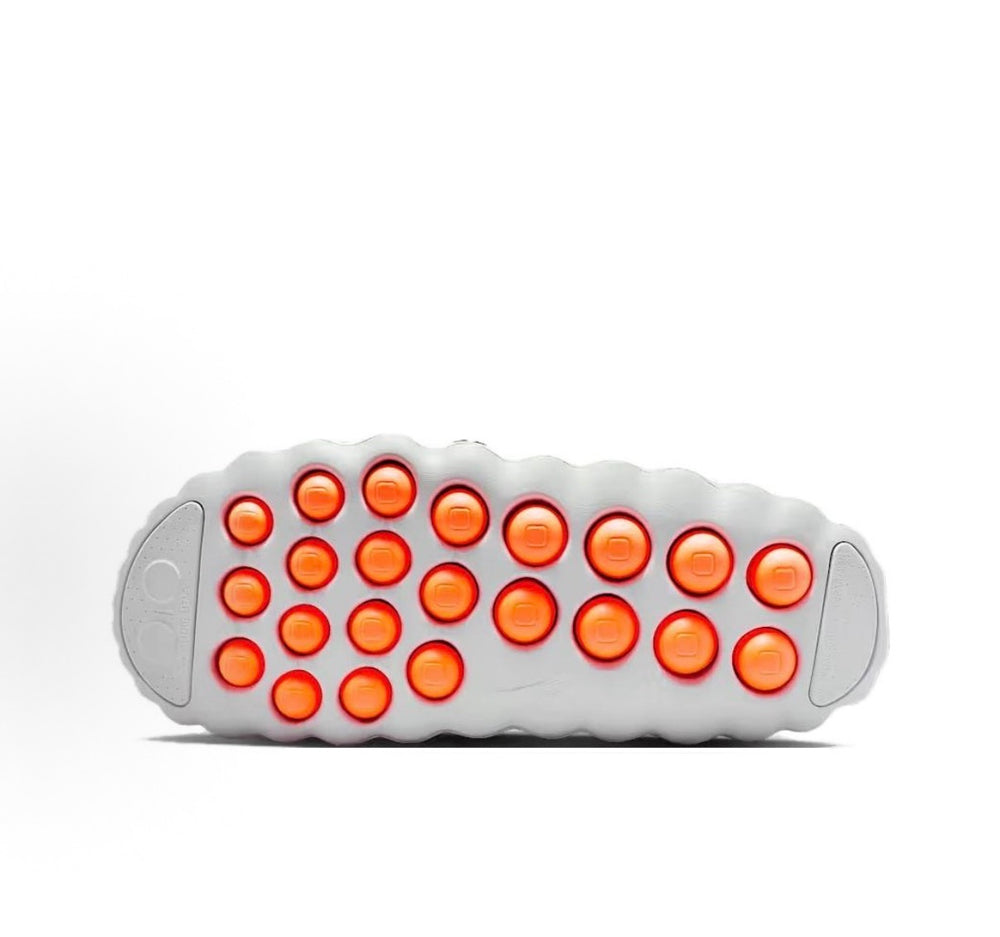 White slide sandal outsole with dense round orange traction pods