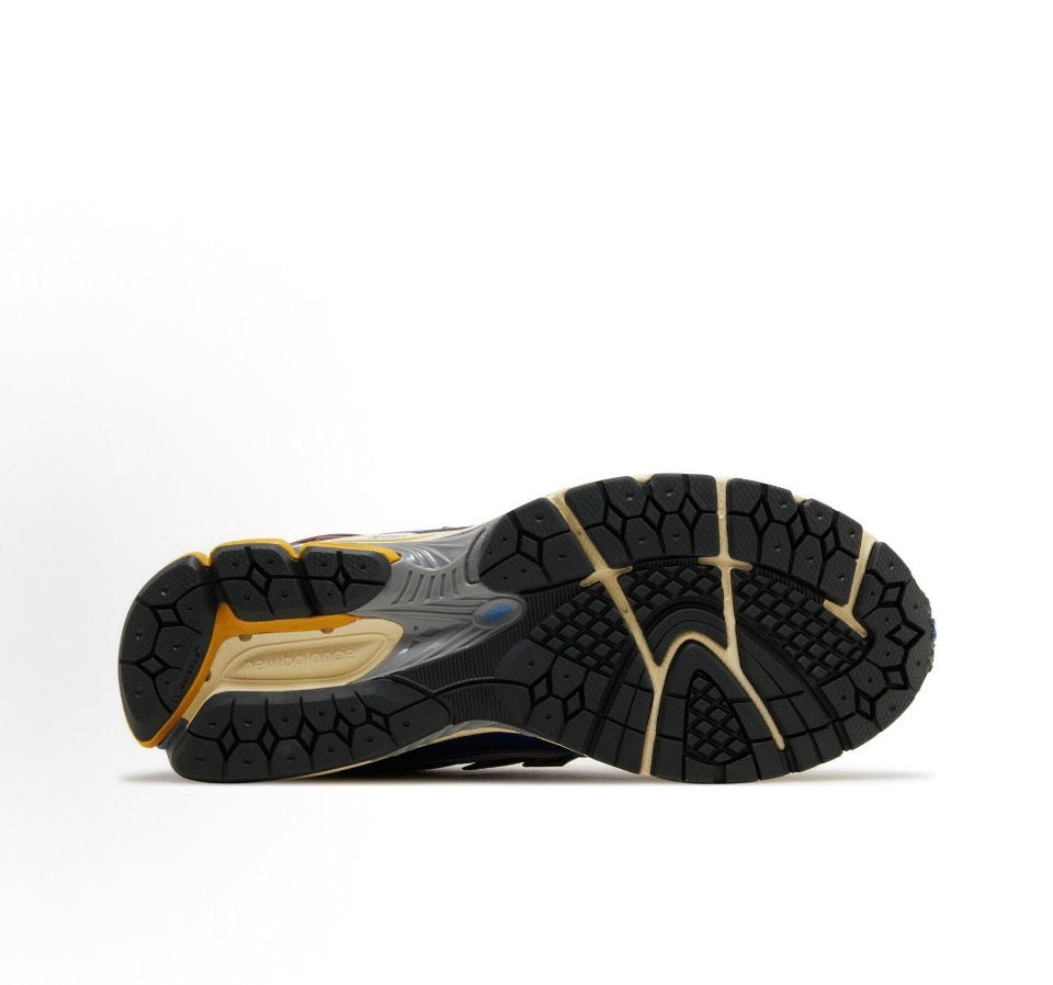 New Balance 1906R outsole view with black hex traction, cream midsole and blue accents