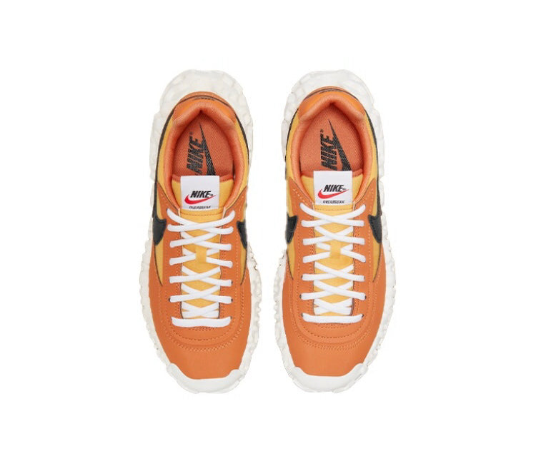 Orange lace-up sneakers with white laces, Nike logo, black trim and panels.