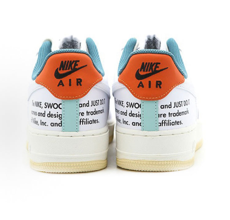 Nike low-top sneakers with orange heel Air logo, teal collar, and white midsole