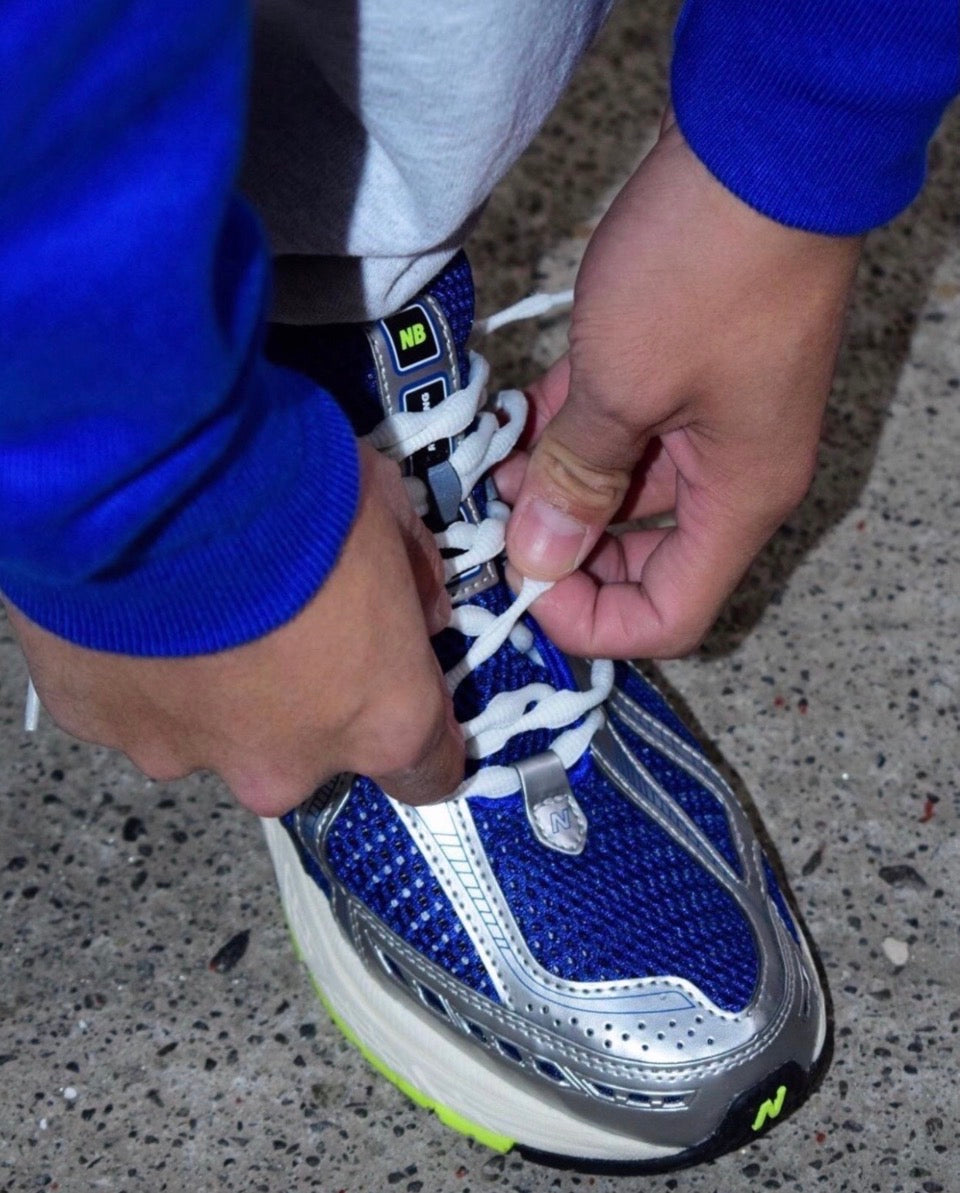 Royal blue and white sneakers with neon green sole detail and NB logo
