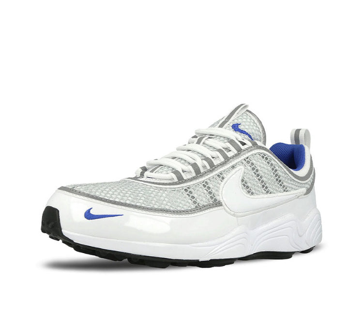 Running shoe side profile, white leather with gray mesh and blue logo