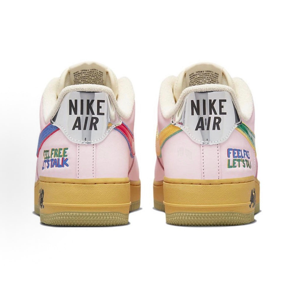 Nike Air Force 1 low-top sneakers with pink uppers, yellow sole, colorful heel details