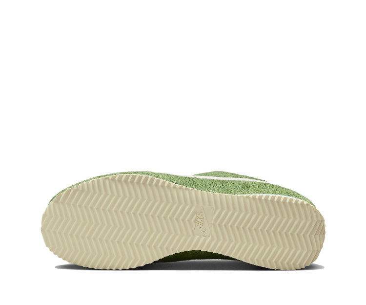 Green suede Nike sneakers with textured zigzag rubber outsole viewed from bottom