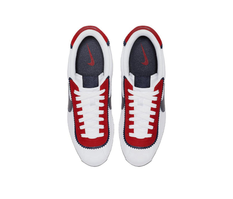 Low-top sneakers with white uppers, red lace details, and navy inner panels