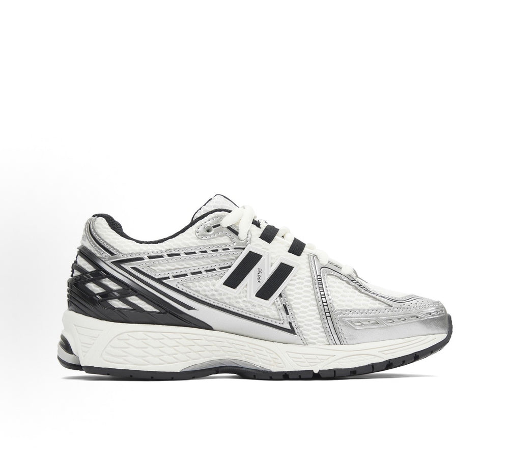New Balance 1906R silver/white sneaker with black accents, lace-up, chunky sole.