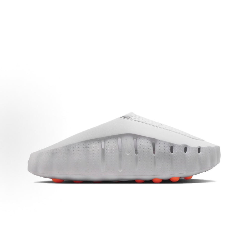 White slide sandal with perforated upper and orange tread pods on outsole
