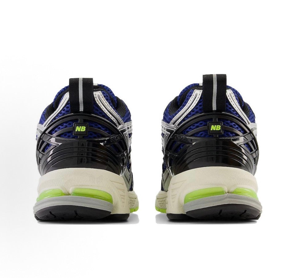 Pair of blue and white sneakers with black heel pods and neon green midsole