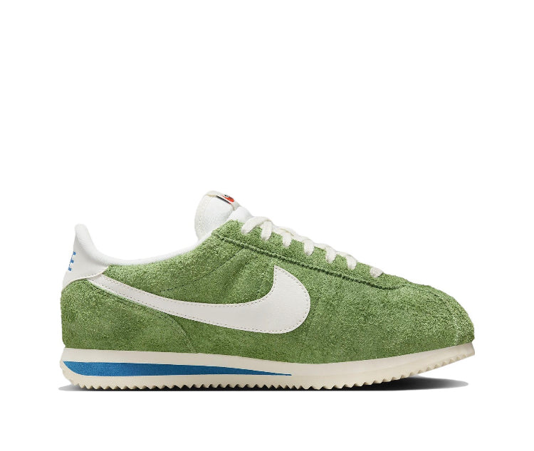 Green suede Nike sneakers with white swoosh and blue-striped rubber sole