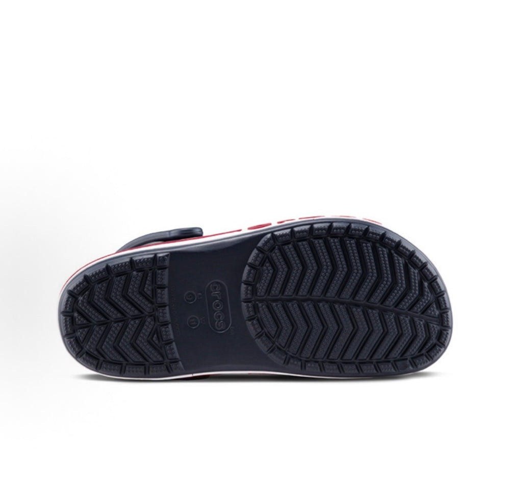 Crocs clog outsole with dark navy tread and chevron pattern, red trim edge