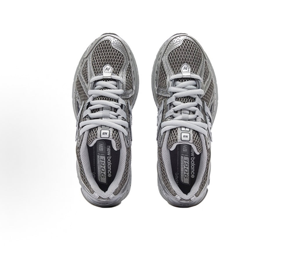 New Balance 1906R sneakers, gray mesh upper with laces and interior brand tag.