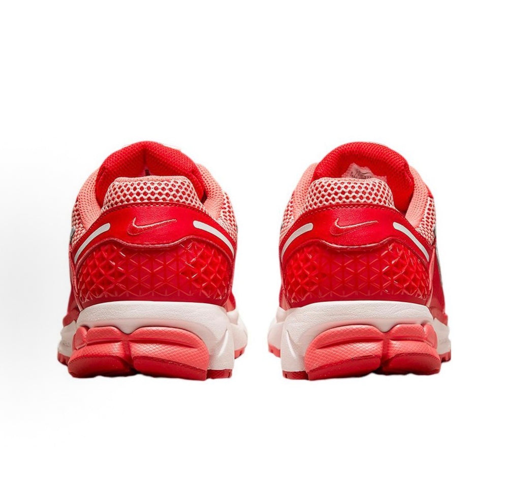 Back view of red mesh Nike sneakers with white cushioning and heel tabs