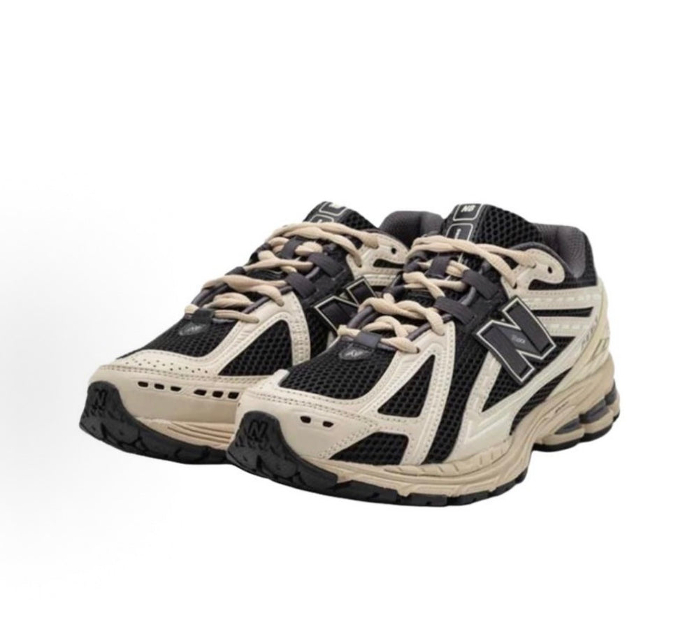 New Balance sneakers front view with beige leather overlays and black mesh panels