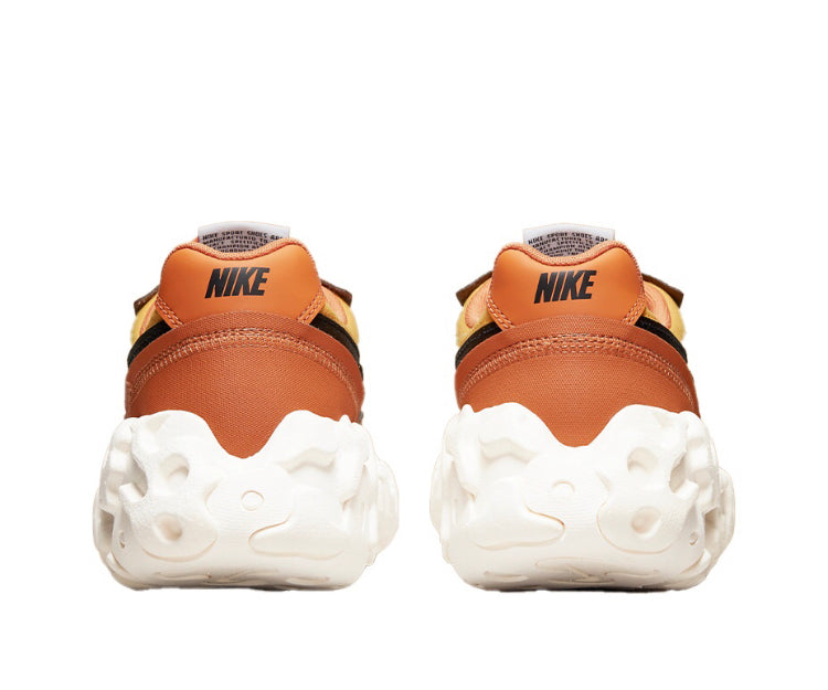 Orange sneakers with Nike heel branding, white chunky sole, lace-up.